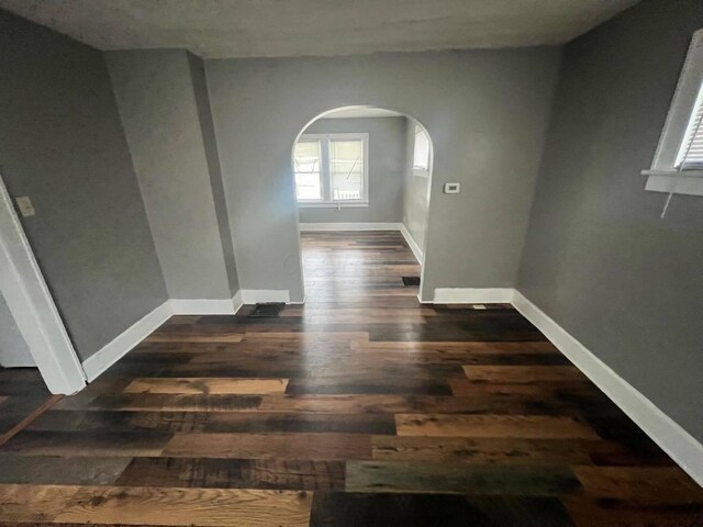 1403 Genessee Ave, Columbus, OH 43211 - spare room featuring arched walkways, dark wood-style flooring, and baseboards