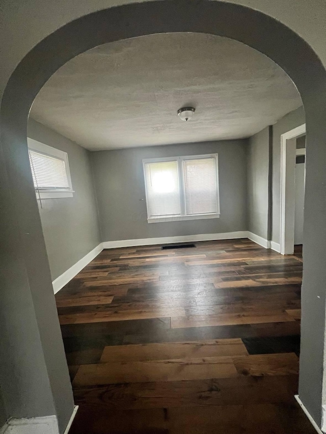1403 Genessee Ave, Columbus, OH 43211 - empty room featuring arched walkways, wood-type flooring, and baseboards