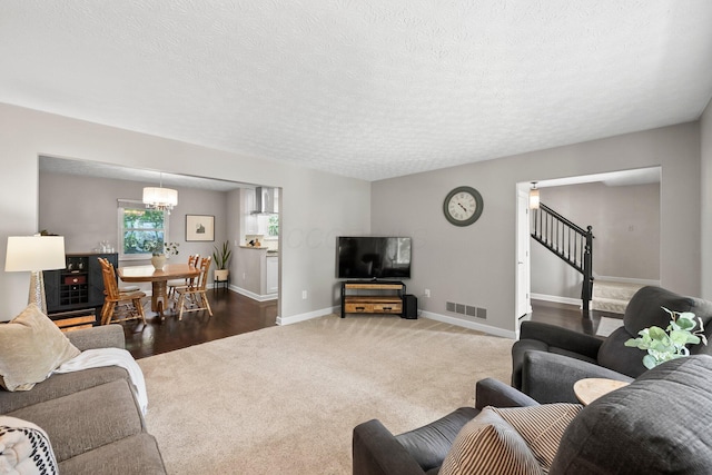 3567 Rochfort Bridge Dr, Columbus, OH 43221 - living area with carpet, baseboards, a chandelier, a textured ceiling, and stairway