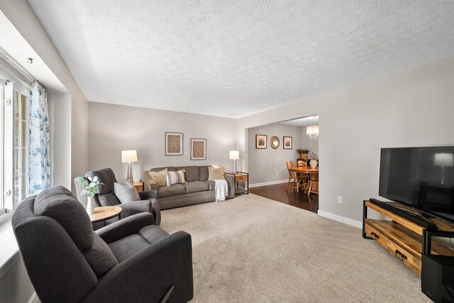 3567 Rochfort Bridge Dr, Columbus, OH 43221 - living area with carpet, a textured ceiling, baseboards, and a chandelier