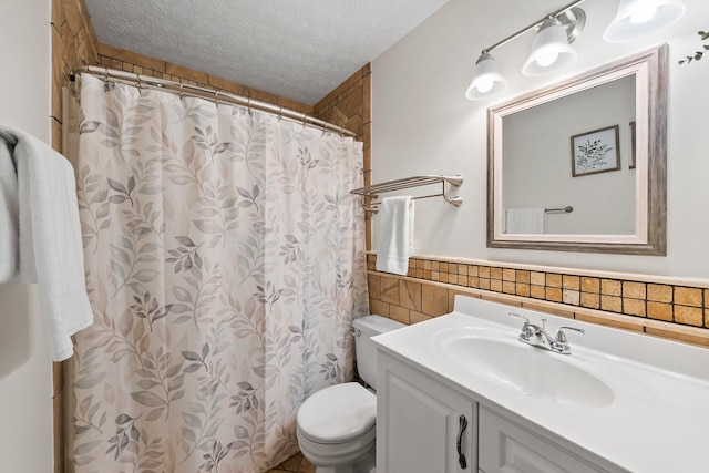 3567 Rochfort Bridge Dr, Columbus, OH 43221 - bathroom featuring toilet, tile walls, vanity, a wainscoted wall, and a textured ceiling