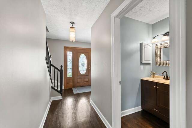 3567 Rochfort Bridge Dr, Columbus, OH 43221 - entrance foyer with baseboards, a textured ceiling, dark wood-type flooring, and stairs