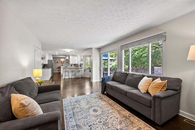 3567 Rochfort Bridge Dr, Columbus, OH 43221 - living room featuring a textured ceiling, dark wood-style flooring, and baseboards