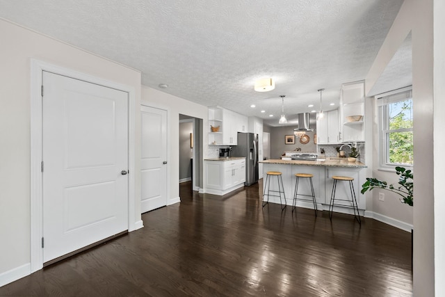 3567 Rochfort Bridge Dr, Columbus, OH 43221 - kitchen with open shelves, appliances with stainless steel finishes, a peninsula, white cabinets, and wall chimney range hood