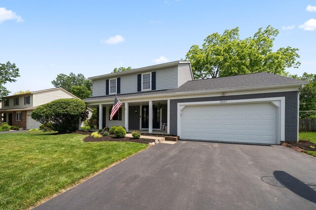 3567 Rochfort Bridge Dr, Columbus, OH 43221 - traditional-style house with driveway, a front yard, a garage, and brick siding