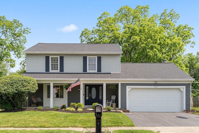 3567 Rochfort Bridge Dr, Columbus, OH 43221 - traditional-style house with a porch, concrete driveway, a garage, a front yard, and brick siding