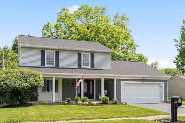 3567 Rochfort Bridge Dr, Columbus, OH 43221 - traditional-style home with an attached garage, driveway, covered porch, a front lawn, and brick siding