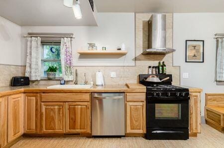 7050 Motts Place Rd, Canal Winchester, OH 43110 - kitchen featuring stainless steel dishwasher, black gas range, wall chimney exhaust hood, and light countertops