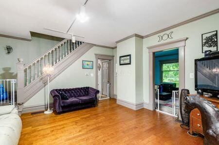 7050 Motts Place Rd, Canal Winchester, OH 43110 - living area featuring ornamental molding, wood finished floors, stairs, track lighting, and baseboards