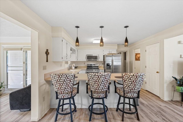 1205 Holton Rd, Grove City, OH 43123 - kitchen featuring appliances with stainless steel finishes, a peninsula, light wood-style floors, and light countertops