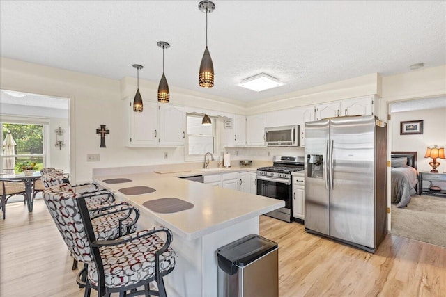 1205 Holton Rd, Grove City, OH 43123 - kitchen featuring appliances with stainless steel finishes, a peninsula, a kitchen breakfast bar, white cabinets, and light countertops