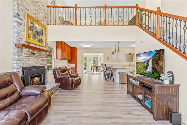 1205 Holton Rd, Grove City, OH 43123 - living room featuring light wood-style floors, a brick fireplace, and a towering ceiling