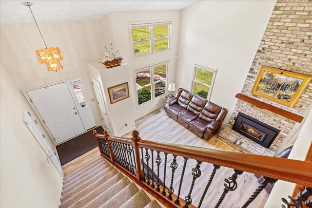 1205 Holton Rd, Grove City, OH 43123 - foyer featuring a high ceiling, a chandelier, a brick fireplace, stairs, and baseboards