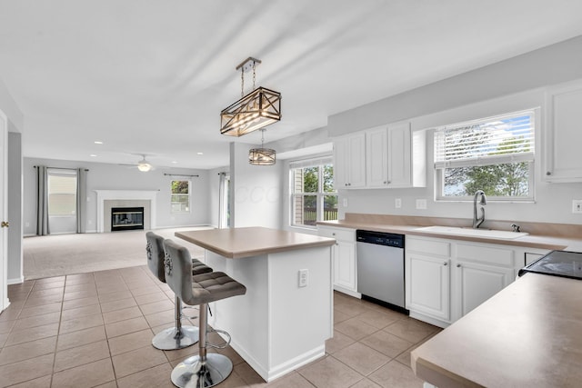 9302 Pimlico Pl, Pickerington, OH 43147 - kitchen featuring stainless steel dishwasher, a sink, light tile patterned floors, a center island, and white cabinetry