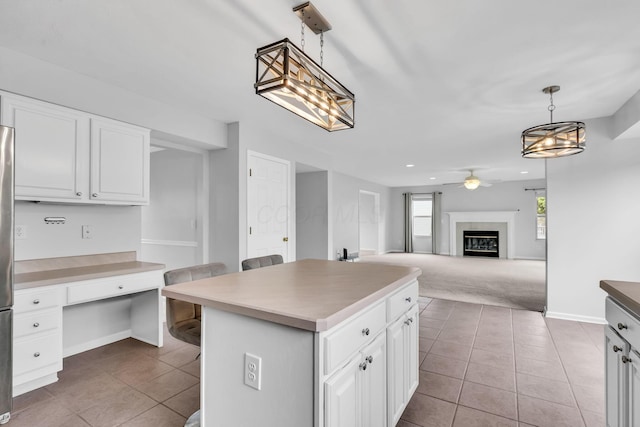 9302 Pimlico Pl, Pickerington, OH 43147 - kitchen featuring tile patterned floors, a ceiling fan, a glass covered fireplace, white cabinetry, and recessed lighting