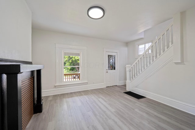 452 N Ohio Ave, Columbus, OH 43203 - unfurnished living room with wood finished floors, healthy amount of natural light, and stairs