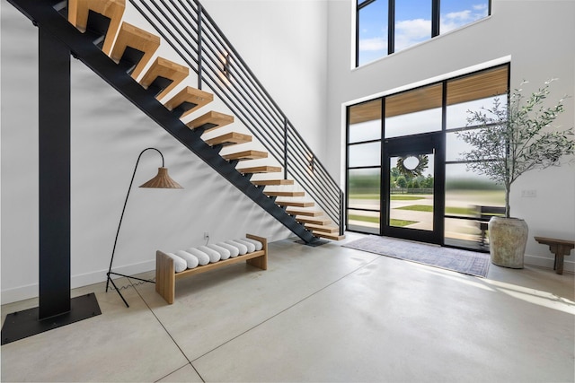 3226 Bean Oller Rd, Delaware, OH 43015 - foyer featuring stairs, finished concrete floors, a towering ceiling, and baseboards