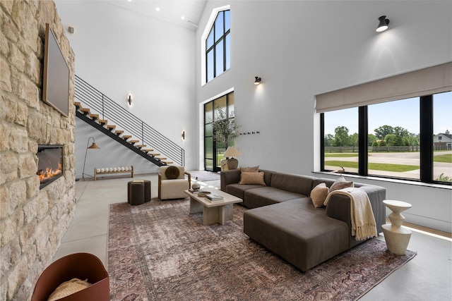 3226 Bean Oller Rd, Delaware, OH 43015 - living area featuring high vaulted ceiling, healthy amount of natural light, a fireplace, and finished concrete floors