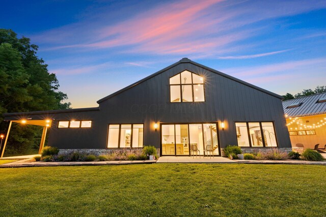 3226 Bean Oller Rd, Delaware, OH 43015 - back of house at dusk featuring a lawn and stone siding