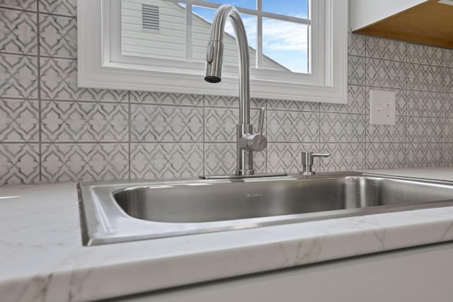 46 S 24th St, Newark, OH 43055 - kitchen view of a sink, white cabinets, light stone countertops, and decorative backsplash