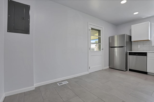 46 S 24th St, Newark, OH 43055 - kitchen featuring stainless steel appliances, electric panel, white cabinets, tasteful backsplash, and baseboards