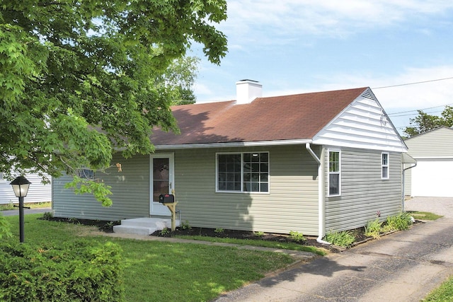 46 S 24th St, Newark, OH 43055 - view of front of property featuring a chimney, a front yard, a shingled roof, and a garage