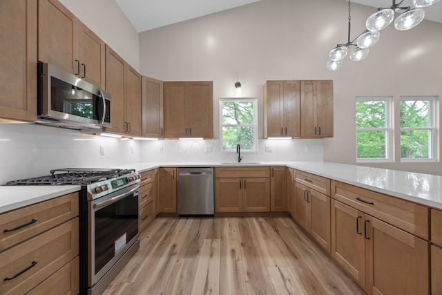 13567 Magers Rd, Howard, OH 43028 - kitchen with stainless steel appliances, a sink, high vaulted ceiling, light wood finished floors, and light countertops