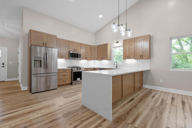 13567 Magers Rd, Howard, OH 43028 - kitchen featuring appliances with stainless steel finishes, high vaulted ceiling, a peninsula, light wood-type flooring, and decorative backsplash