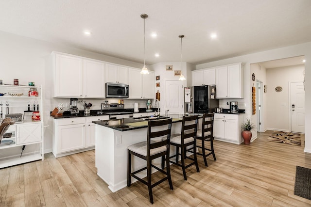 99 Hutchison St, South Bloomfield, OH 43103 - kitchen with appliances with stainless steel finishes, light wood finished floors, dark countertops, white cabinets, and recessed lighting