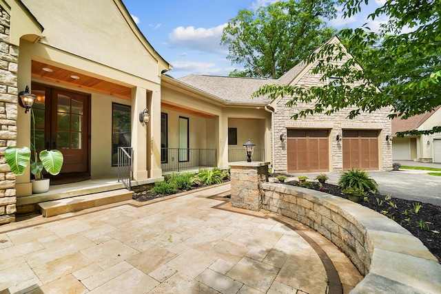 5633 Travis Pointe Ct, Westerville, OH 43082 - property entrance featuring stucco siding, stone siding, a porch, an attached garage, and driveway