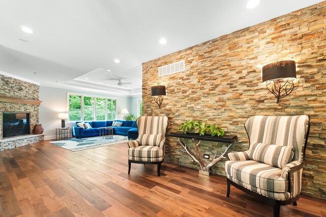 5633 Travis Pointe Ct, Westerville, OH 43082 - living room featuring a fireplace, ornamental molding, recessed lighting, wood finished floors, and a raised ceiling
