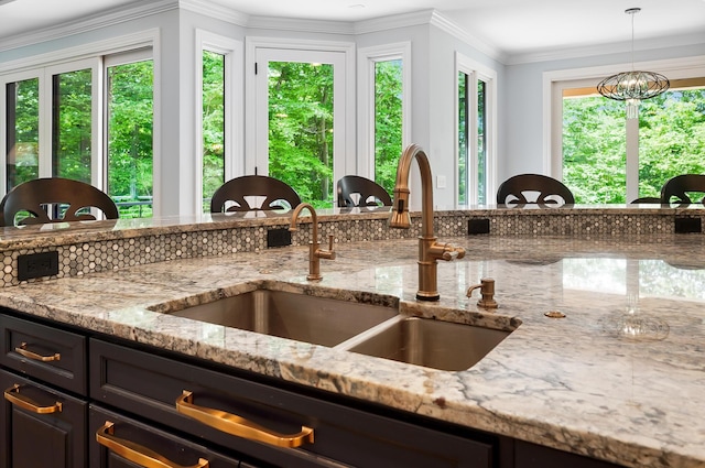 5633 Travis Pointe Ct, Westerville, OH 43082 - kitchen featuring a sink, light stone countertops, decorative light fixtures, and crown molding