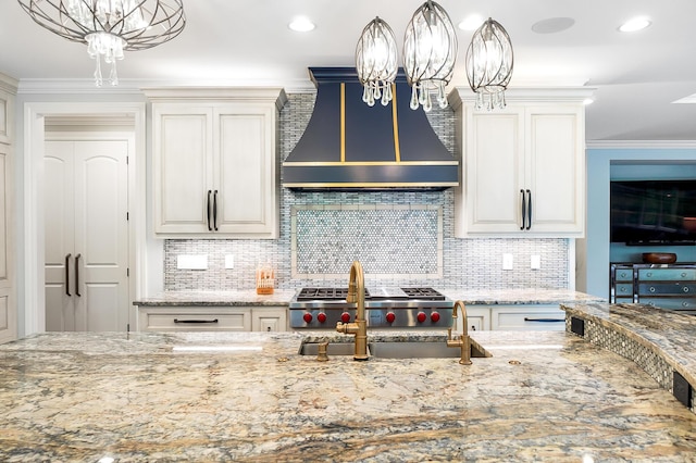 5633 Travis Pointe Ct, Westerville, OH 43082 - kitchen with range hood, light stone countertops, backsplash, a chandelier, and hanging light fixtures