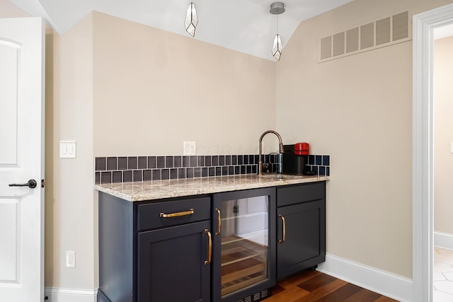 5633 Travis Pointe Ct, Westerville, OH 43082 - indoor wet bar featuring beverage cooler, baseboards, lofted ceiling, dark wood-style flooring, and pendant lighting