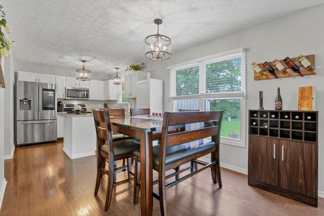 5035 Dietrich Ave, Orient, OH 43146 - dining space with a chandelier, dark wood finished floors, a textured ceiling, and baseboards