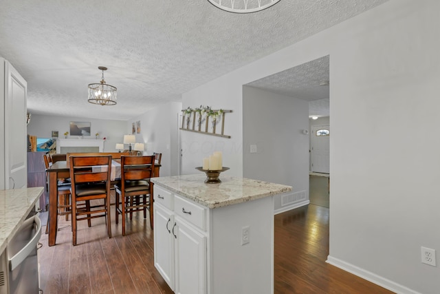 5035 Dietrich Ave, Orient, OH 43146 - kitchen featuring dark wood-type flooring, a textured ceiling, white cabinets, pendant lighting, and a chandelier