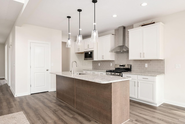 7014 Aster Way, Plain City, OH 43064 - kitchen with stainless steel appliances, wall chimney range hood, a sink, wood finished floors, and white cabinetry