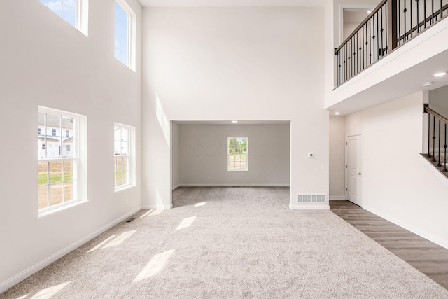 7014 Aster Way, Plain City, OH 43064 - unfurnished living room with a high ceiling, carpet, stairway, and baseboards