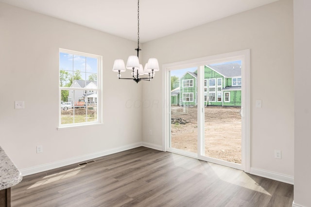 7014 Aster Way, Plain City, OH 43064 - unfurnished dining area with wood finished floors, a chandelier, plenty of natural light, and baseboards