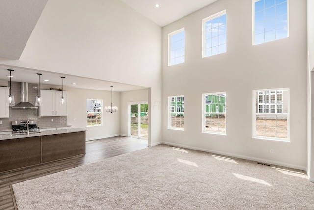 7014 Aster Way, Plain City, OH 43064 - unfurnished living room featuring a high ceiling, dark colored carpet, a chandelier, dark wood-type flooring, and baseboards
