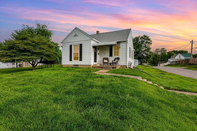12 E Vine St, Jackson, OH 45640 - view of front of home featuring covered porch, a chimney, a front lawn, and metal roof
