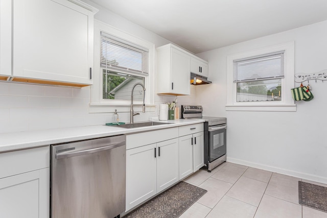 12 E Vine St, Jackson, OH 45640 - kitchen featuring appliances with stainless steel finishes, a sink, under cabinet range hood, decorative backsplash, and light countertops