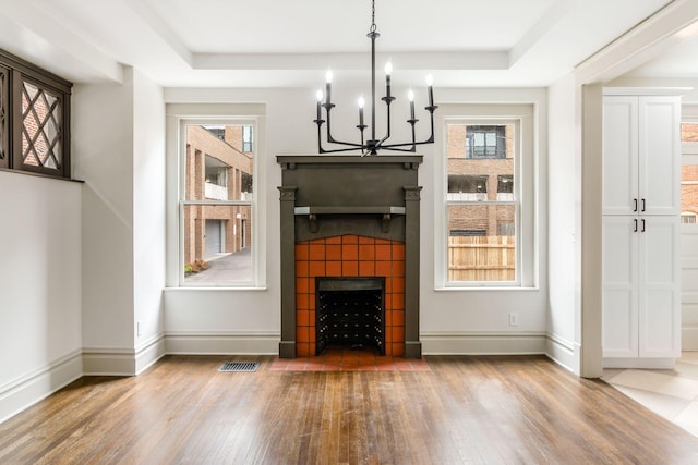 37 W 2nd Ave, Columbus, OH 43201 - unfurnished living room with a chandelier, wood finished floors, healthy amount of natural light, and a raised ceiling