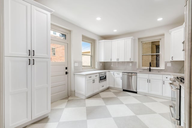 37 W 2nd Ave, Columbus, OH 43201 - kitchen featuring appliances with stainless steel finishes, light floors, a sink, light countertops, and recessed lighting
