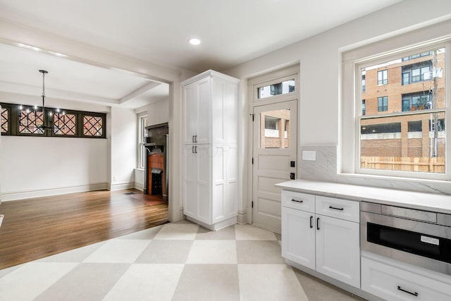37 W 2nd Ave, Columbus, OH 43201 - kitchen with light floors, white cabinetry, recessed lighting, hanging light fixtures, and a chandelier