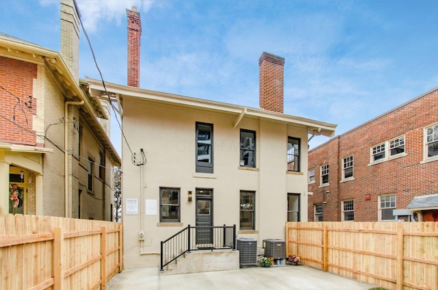 37 W 2nd Ave, Columbus, OH 43201 - rear view of property featuring stucco siding, a chimney, and central air condition unit