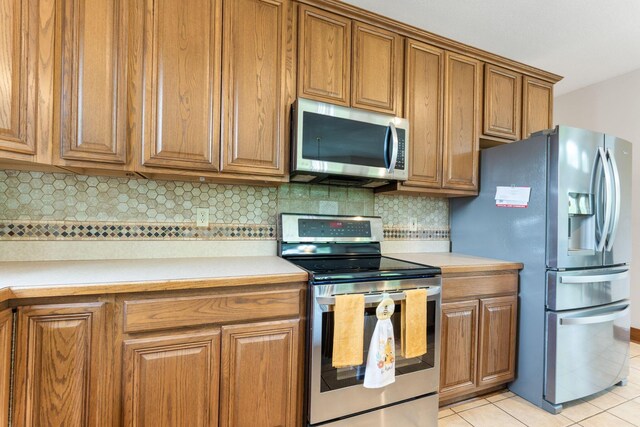 5103 Johnstown Alexandria Rd, Johnstown, OH 43031 - kitchen featuring appliances with stainless steel finishes, brown cabinetry, and light countertops