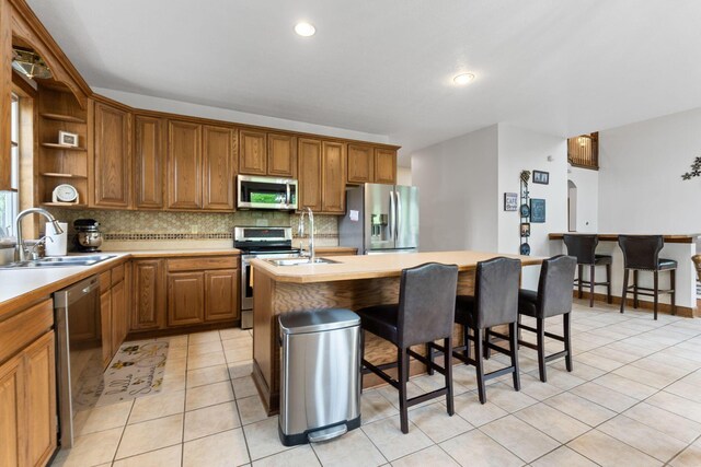 5103 Johnstown Alexandria Rd, Johnstown, OH 43031 - kitchen featuring stainless steel appliances, a sink, decorative backsplash, an island with sink, and light tile patterned flooring