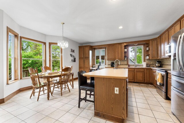 5103 Johnstown Alexandria Rd, Johnstown, OH 43031 - kitchen with stainless steel appliances, light countertops, decorative backsplash, a sink, and a chandelier