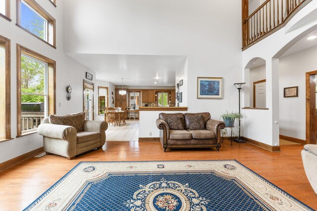 5103 Johnstown Alexandria Rd, Johnstown, OH 43031 - living area with a high ceiling, light wood-style floors, arched walkways, and baseboards